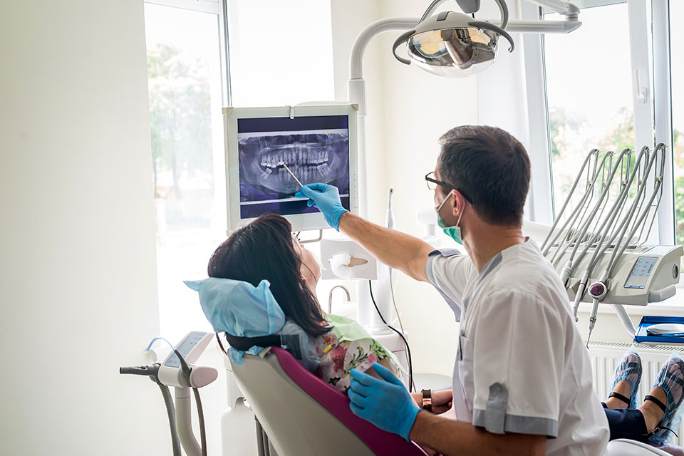 Gabinet stomatologiczno-ortodontyczny, lekarz, pacjentka na fotelu, na drugim planie monitor z pantomogramem 1